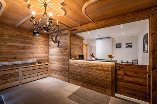 サースフェーにあるホテル クリスティアニアの木製の壁とシャンデリアが備わる広い客室です。
