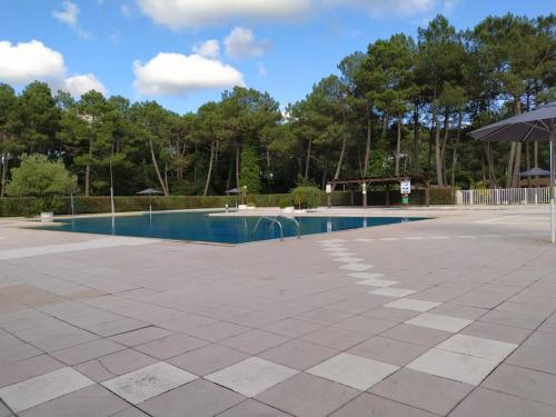 une piscine vide dans un parc avec un parasol dans l'établissement Agréable chalet à Gujan-Mestras, à Gujan-Mestras