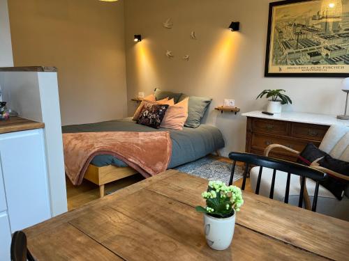 um pequeno quarto com uma cama e uma mesa em Studio de charme avec terrasse privée em Bouxwiller