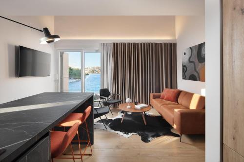 a living room with a couch and a table at Modern Seafront Villa Steps from the Beach in Rogoznica
