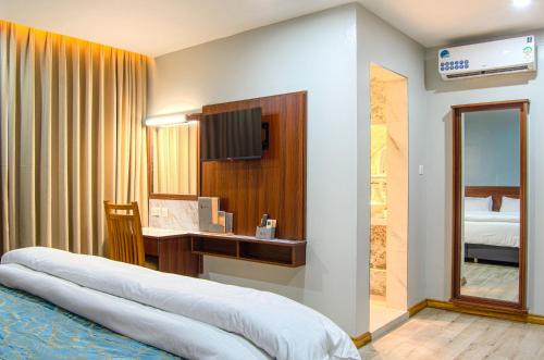 1 dormitorio con cama y escritorio con espejo en La Fattoria Resort en Mombasa