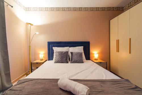 une chambre avec un lit avec une tête de lit bleue et deux lampes dans l'établissement F2 coquet à Disney-Parking-WIFI, à Bussy-Saint-Georges