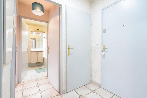 un couloir avec une porte menant à une salle de bains. dans l'établissement F2 coquet à Disney-Parking-WIFI, à Bussy-Saint-Georges