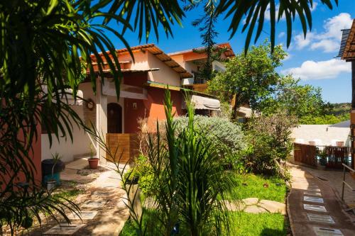una casa en medio de un patio con plantas en Chalés Alto Da Estância en Alto Paraíso de Goiás