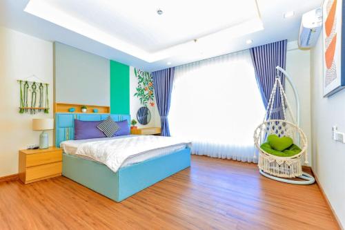 ein Schlafzimmer mit einem blauen Bett in einem Zimmer in der Unterkunft CĂN HỘ CAO CẤP FLC SEATOWN QUY NHƠN in Quy Nhon