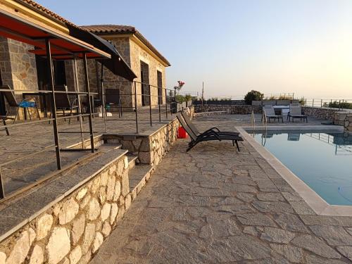 a swimming pool with a bench next to a building at Point of View Andromeda in Drymon