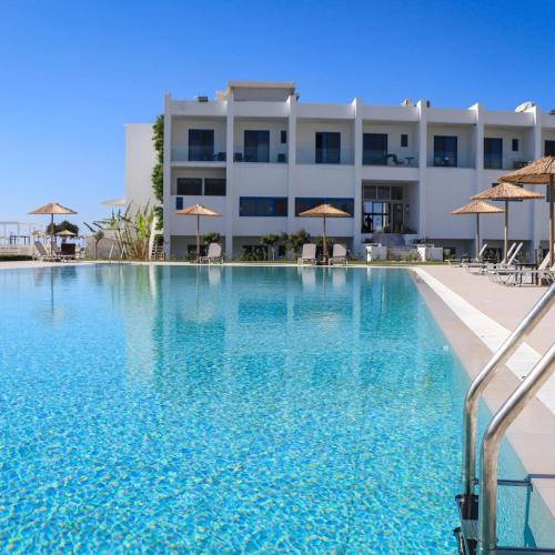 a large swimming pool in front of a building at Kamari Beach in Lardos