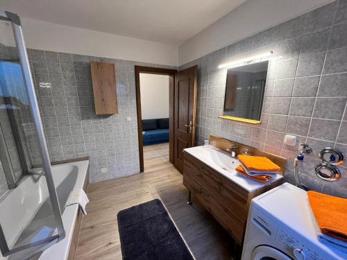 uma casa de banho com uma banheira, um lavatório e uma máquina de lavar roupa em Ferienwohnung Strohmeyer em Oberaudorf