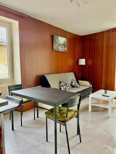 sala de estar con mesa y sofá en Au bord de la Furieuse, proche de la Grande Saline et des Thermes de Salins-les-Bains en Salins-les-Bains