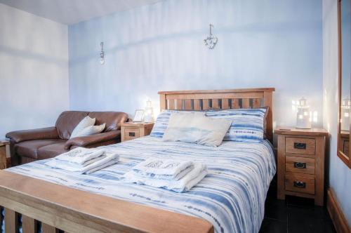 a bedroom with a bed with towels on it at Primrose - 1 Bedroom Cottage - Llanteg in Crunwear