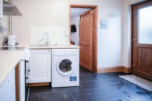 a kitchen with a washing machine and a sink at Primrose - 1 Bedroom Cottage - Llanteg in Crunwear