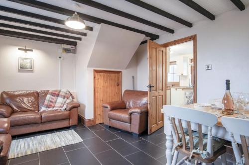 a living room with leather furniture and a table at The Brambles - 2 bedroom Cottage - Llanteg in Pembrokeshire