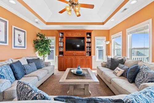 a living room with a couch and a tv at Cherry Bomb Private heated Pool, Elevator in Ocean Isle Beach
