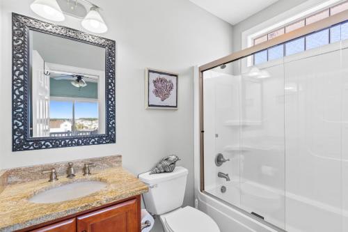 a bathroom with a shower and a toilet and a sink at Cherry Bomb Private heated Pool, Elevator in Ocean Isle Beach