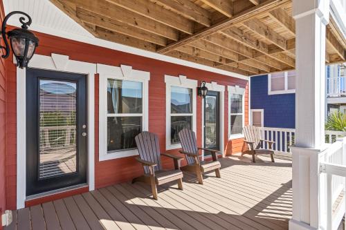 a porch with chairs and a table on a house at Cherry Bomb Private heated Pool, Elevator in Ocean Isle Beach