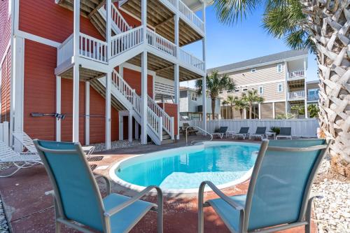 a patio with two chairs and a swimming pool at Cherry Bomb Private heated Pool, Elevator in Ocean Isle Beach