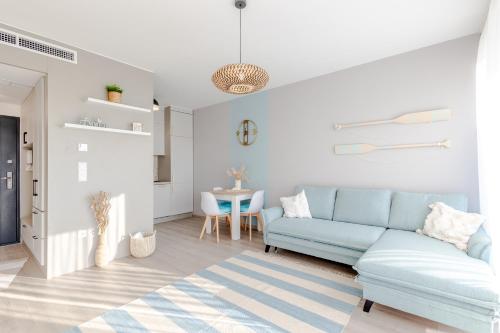 a living room with a blue couch and a table at LelleMarine by BLTN Apartmanok Balatonlelle in Balatonlelle