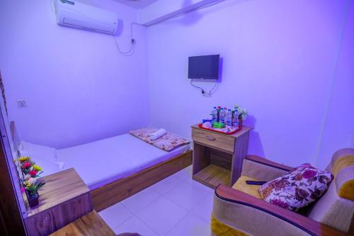 ein kleines Zimmer mit einem kleinen Bett und einem Tisch in der Unterkunft Hotel City International Green Road in Dhaka