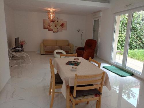 sala de estar con mesa y sillas en cosy appartement 6 pers grand jardin, en Vitry-sur-Seine