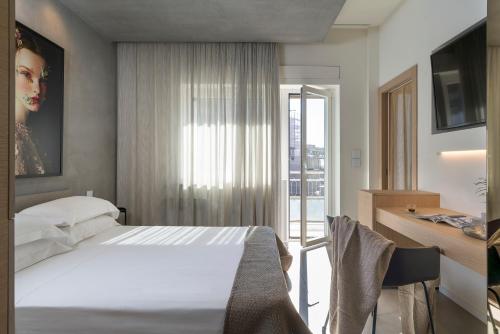 1 dormitorio con cama, escritorio y ventana en Catania Smart Apartments, en Catania