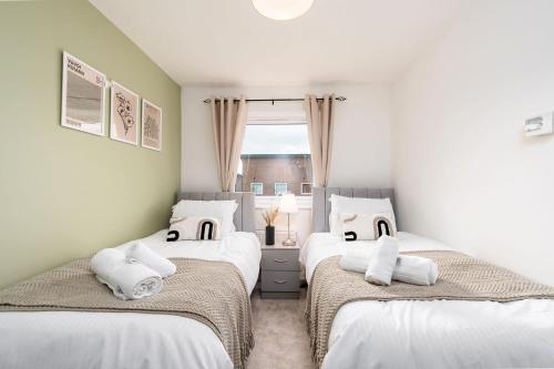 1 dormitorio con 2 camas con sábanas blancas y ventana en 6 Guests - 3 Bedrooms - Free WI-FI - Manchester en Mánchester