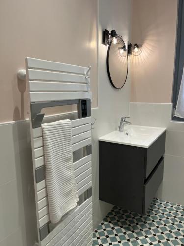 uma casa de banho branca com um lavatório e um espelho em Studio de charme avec terrasse privée em Bouxwiller