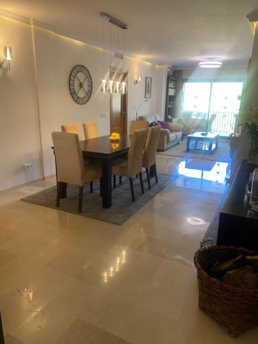a dining room and living room with a table and chairs at Modern Apartment in Benahavis Village Centre with Underground Parking in Benahavís