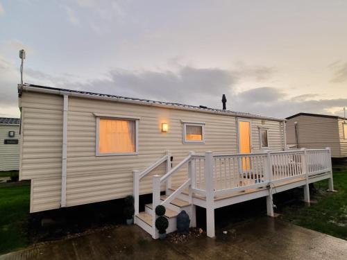a mobile home with a porch and a person on the roof at CASALIE at Seasalter Whitstable in Seasalter