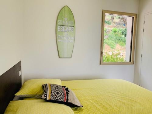 - une chambre avec un lit et une planche de surf sur le mur dans l'établissement Lodge Calédonie, à Solliès-Pont