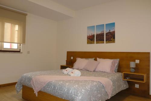 a bedroom with a bed with a teddy bear on it at Outeiro do Moinho in Campo do Gerês