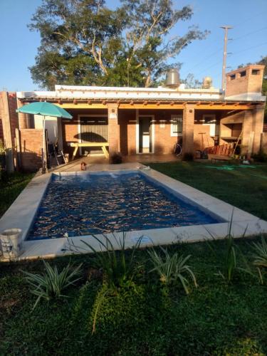 a swimming pool in the backyard of a house at DIVINA CASITA PASO DE LA PATRIA in Paso de la Patria