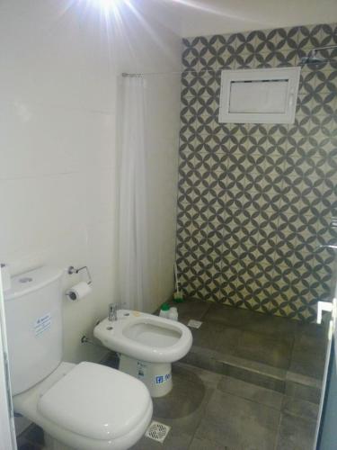 a bathroom with a white toilet and a sink at DIVINA CASITA PASO DE LA PATRIA in Paso de la Patria