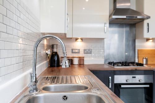 a kitchen with a sink and a stove at 6 Guests - 3 Bedrooms - Free WI-FI - Manchester in Manchester