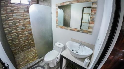 ein Badezimmer mit einem Waschbecken, einem WC und einem Spiegel in der Unterkunft Casa Sëlë in Fortuna