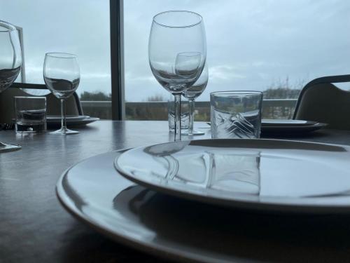 a table with wine glasses and a plate on it at Apartment Appartement 64-202 by Interhome in Bredene