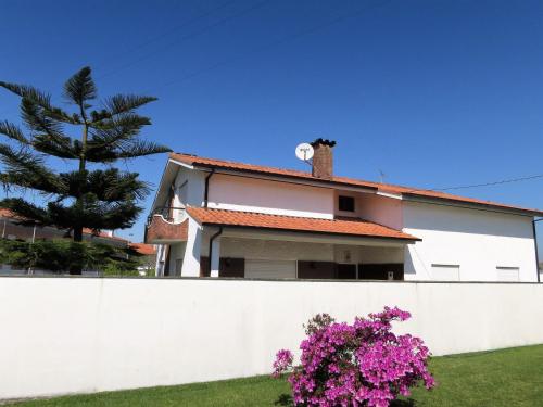 a house behind a white fence with pink flowers at Holiday Home Marta - ESP110 by Interhome in Esposende