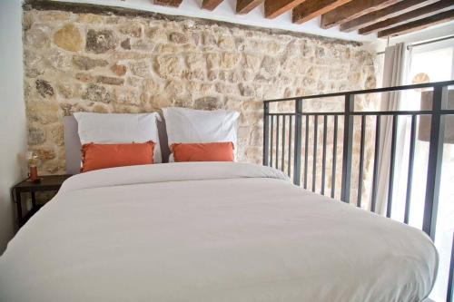 a bedroom with a white bed and a stone wall at Charming loft in the heart of Paris in Paris