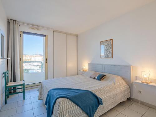1 dormitorio con cama y ventana grande en Apartment L'Open-12 by Interhome, en Fréjus