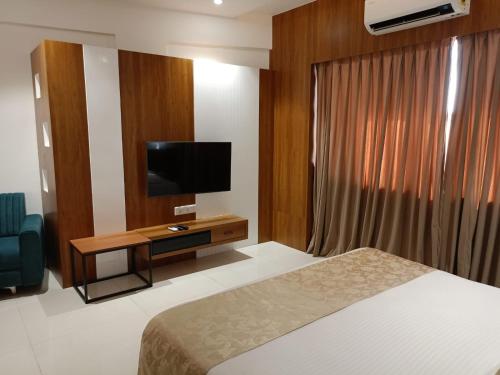a hotel room with a bed and a flat screen tv at Lords Eco Inn, Ambaji in Ambaji
