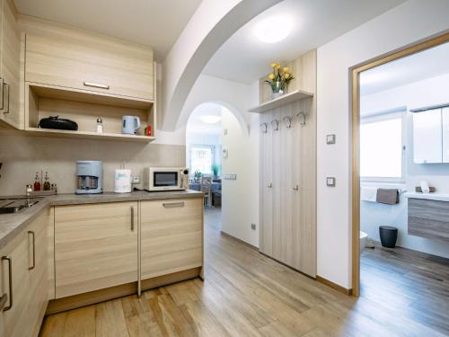 une cuisine avec des placards en bois et une grande porte dans l'établissement Apartment Spieglhof-2 by Interhome, à Sarentino