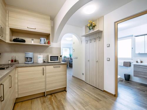 a kitchen with wooden cabinets and a large door at Apartment Spieglhof-2 by Interhome in Sarntal