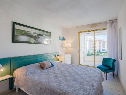 sypialnia z łóżkiem, krzesłem i oknem w obiekcie Apartment L'Open-1 by Interhome w Fréjus