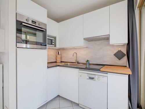 eine weiße Küche mit einer Spüle und einem Kühlschrank in der Unterkunft Apartment L'Open-5 by Interhome in Fréjus
