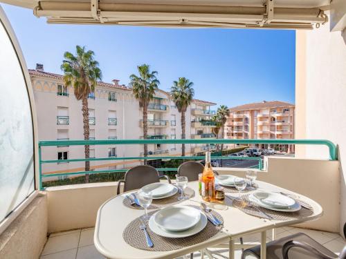 - une table sur un balcon avec vue sur un bâtiment dans l'établissement Apartment L'Open-5 by Interhome, à Fréjus