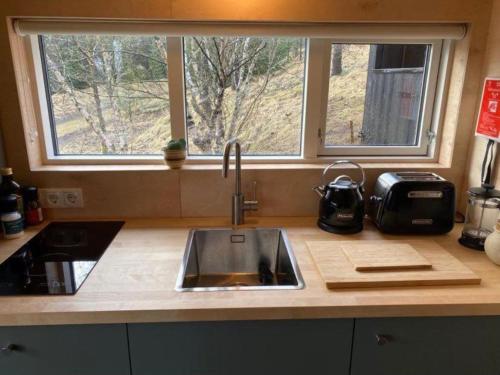 a kitchen counter with a sink and a window at Audkula Dome Cabin in Hella