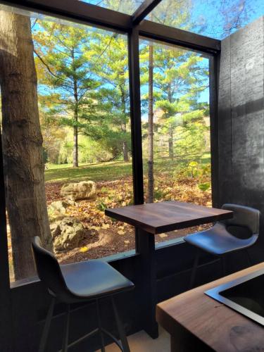 een tafel en stoelen in een kamer met een groot raam bij Black Pine Tree House in Acton
