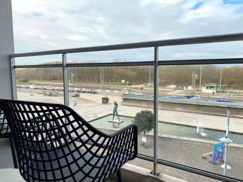 a bench sitting on a balcony looking out at a playground at Apartment Queen Mary 302 with balcony by Interhome in Bredene