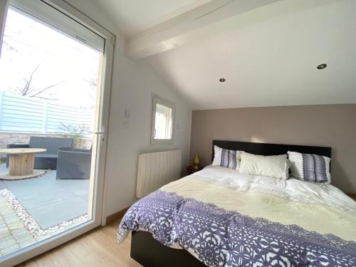 a bedroom with a bed and a large window at Villa 6 chambres avec piscine et vue exceptionnelle in Saint-Genis-Laval