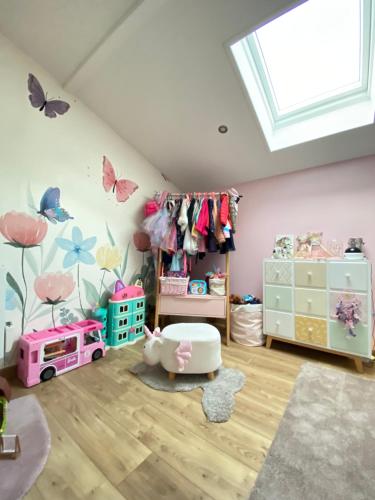 a childs room with a pink wall with butterflies at Villa 6 chambres avec piscine et vue exceptionnelle in Saint-Genis-Laval