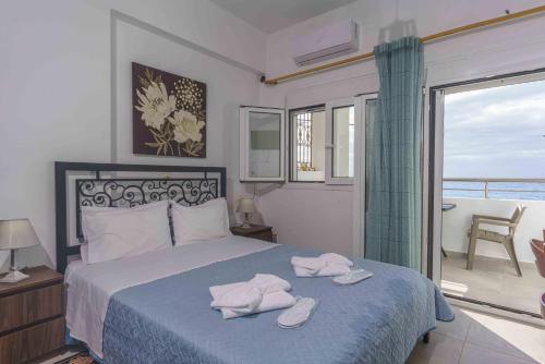 ein Schlafzimmer mit einem Bett mit zwei Handtüchern darauf in der Unterkunft Ioannis Rooms Δωμάτια με θεα στη θαλασσα in Paránimfoi